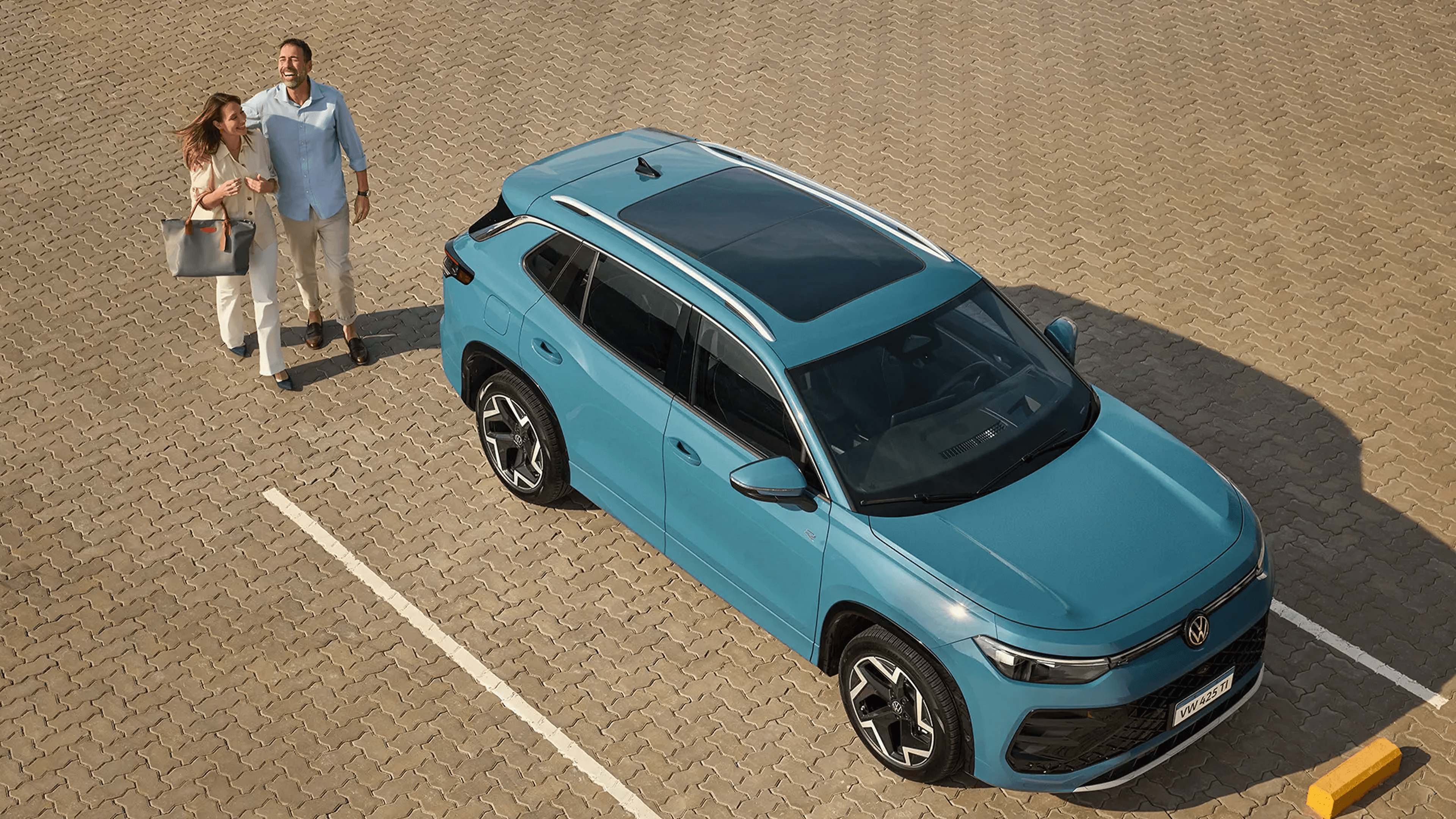 Novo Tiguan R-Line azul visto de cima com pessoas ao lado